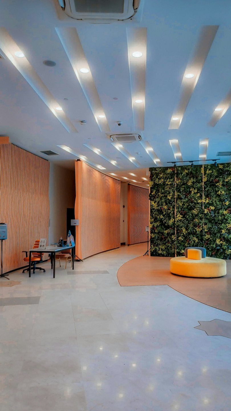 Modern hotel lobby featuring a wooden wall and green plant wall.