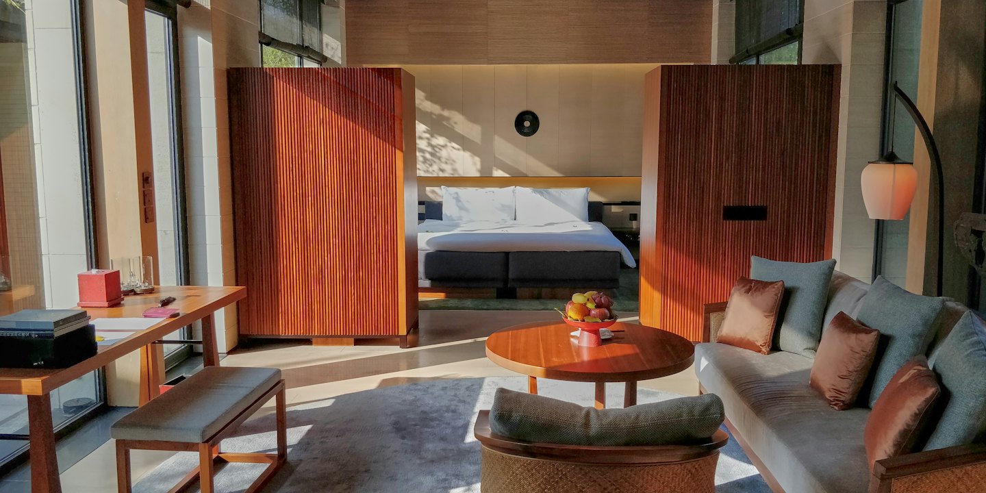 Modern hotel suite with a living area and connected bedroom.