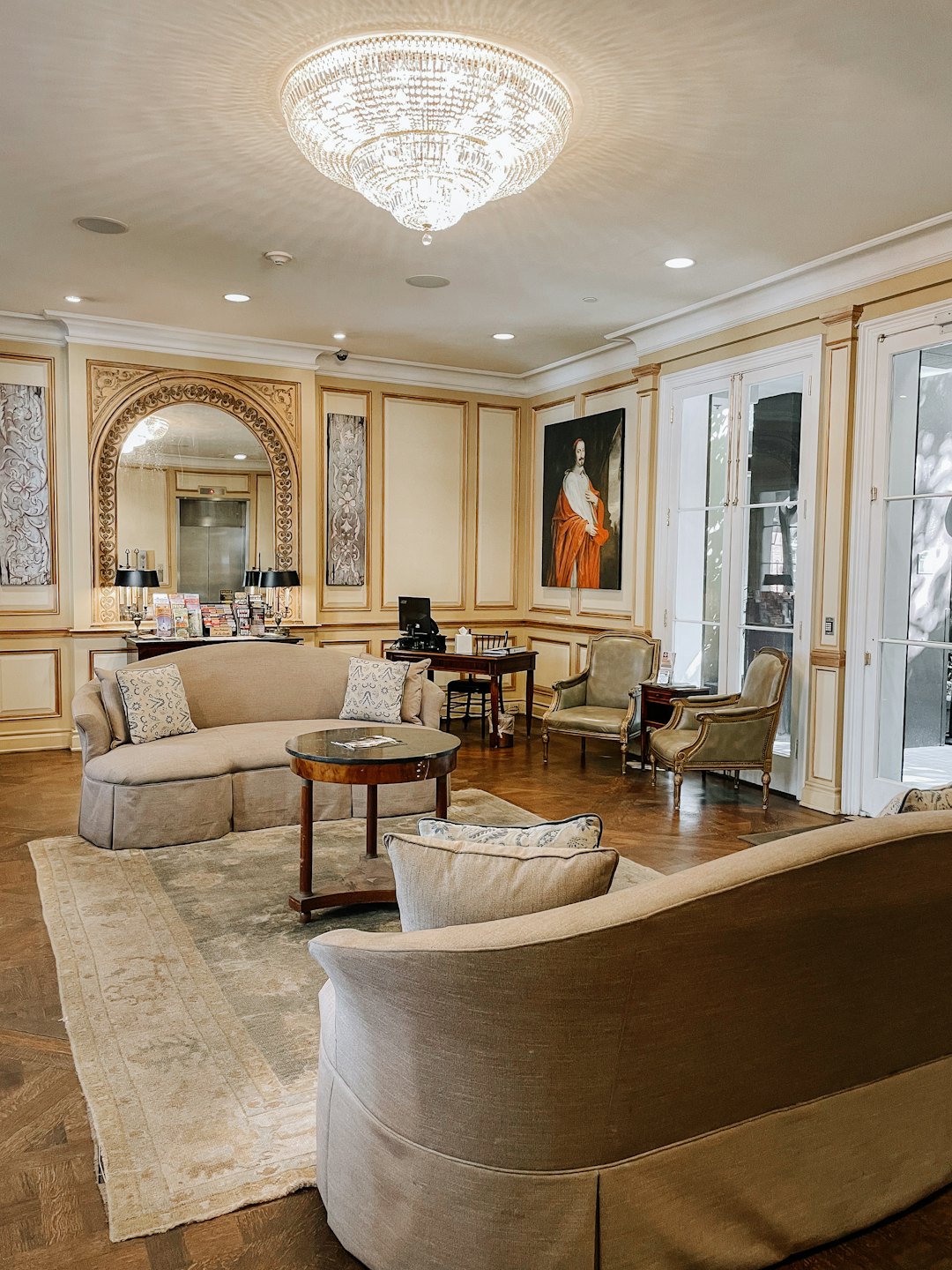 Elegant hotel lobby with plush seating and ornate chandelier.