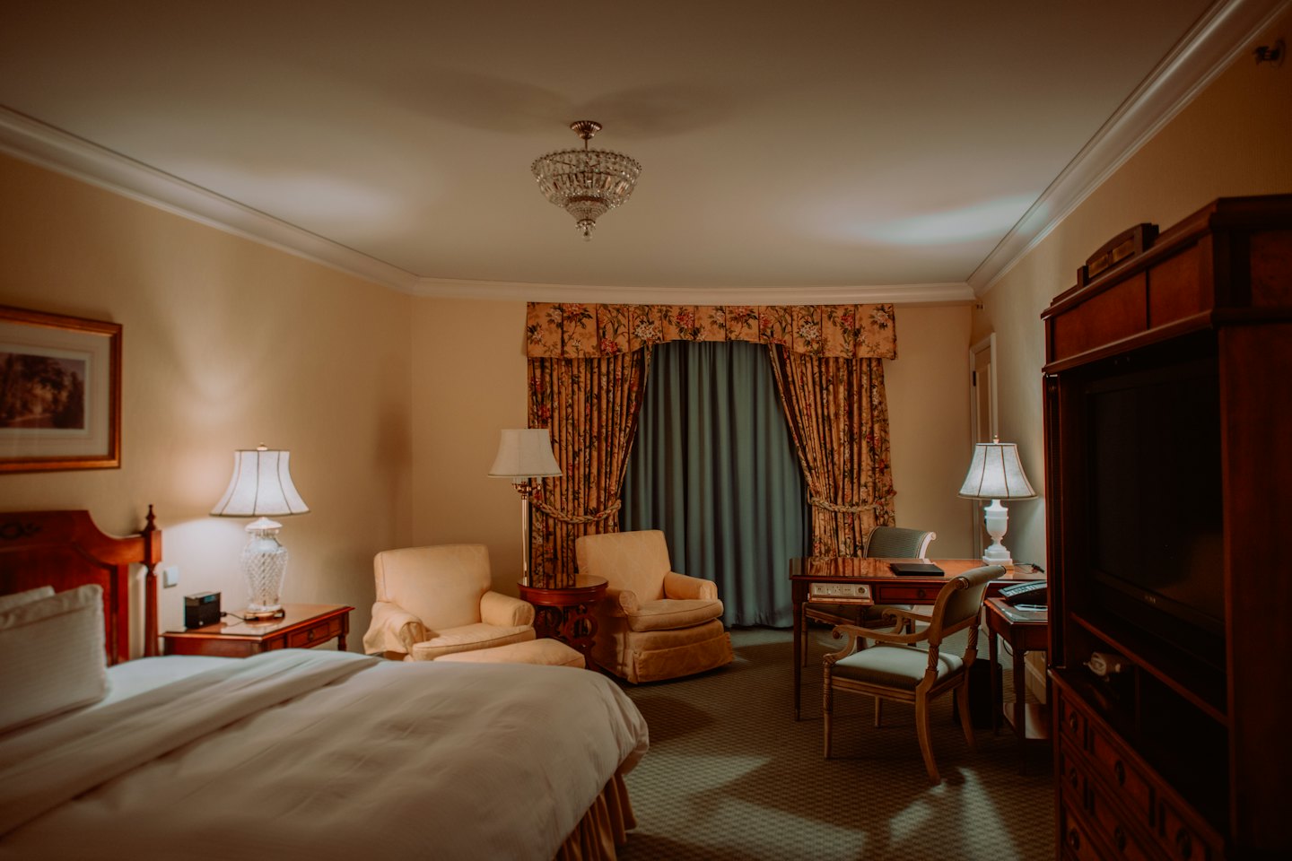 Cozy hotel room with a large bed and warm lighting.